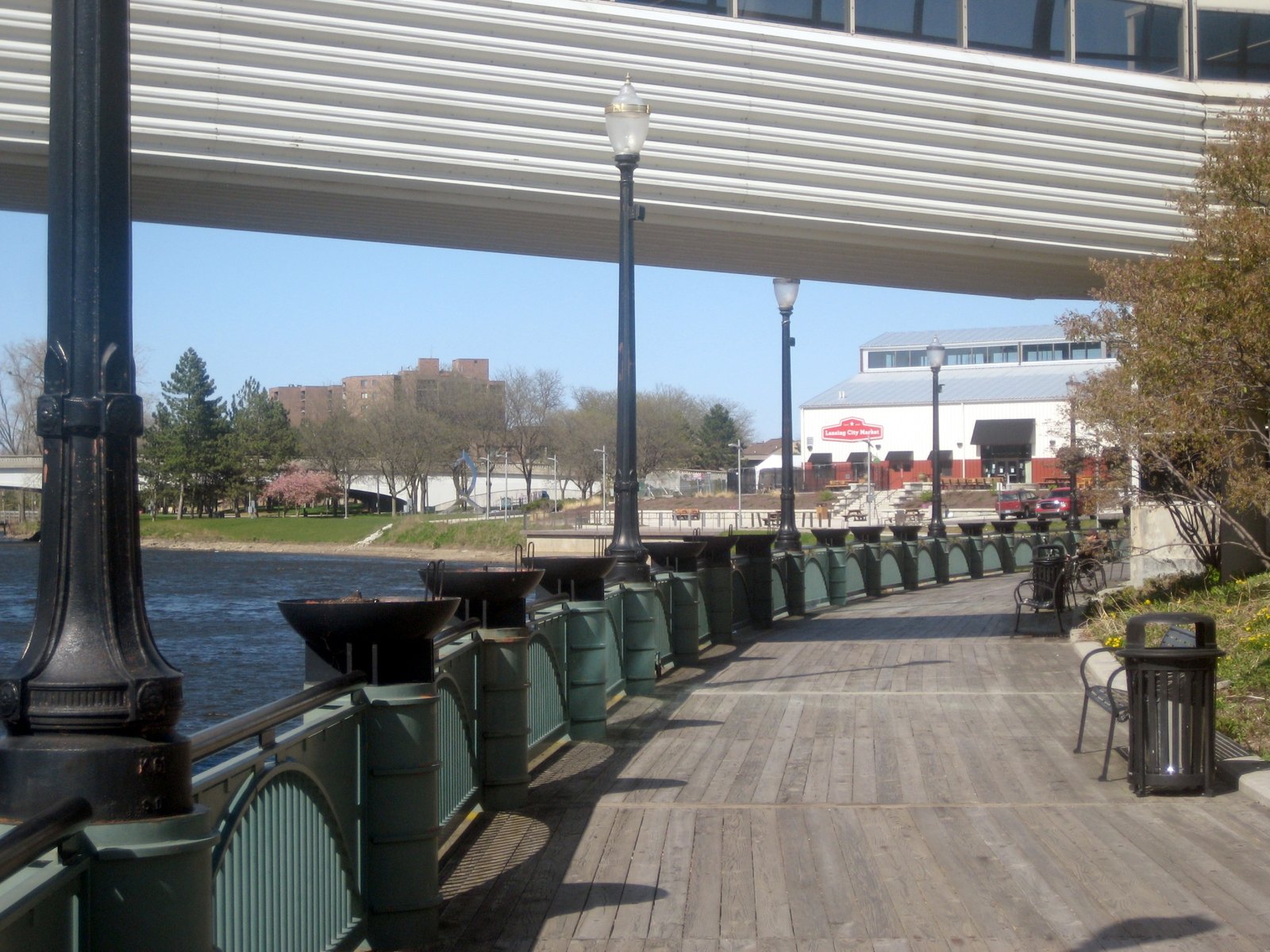 The Lansing River Trail riverwalk along the Grand River in downtown Lansing, with the City Market in view